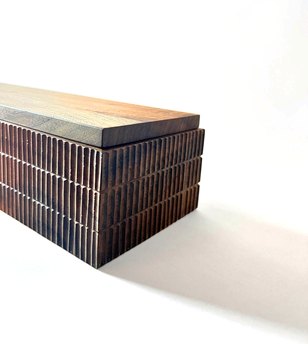 Modern bench with wooden top and textured metal base on a white background