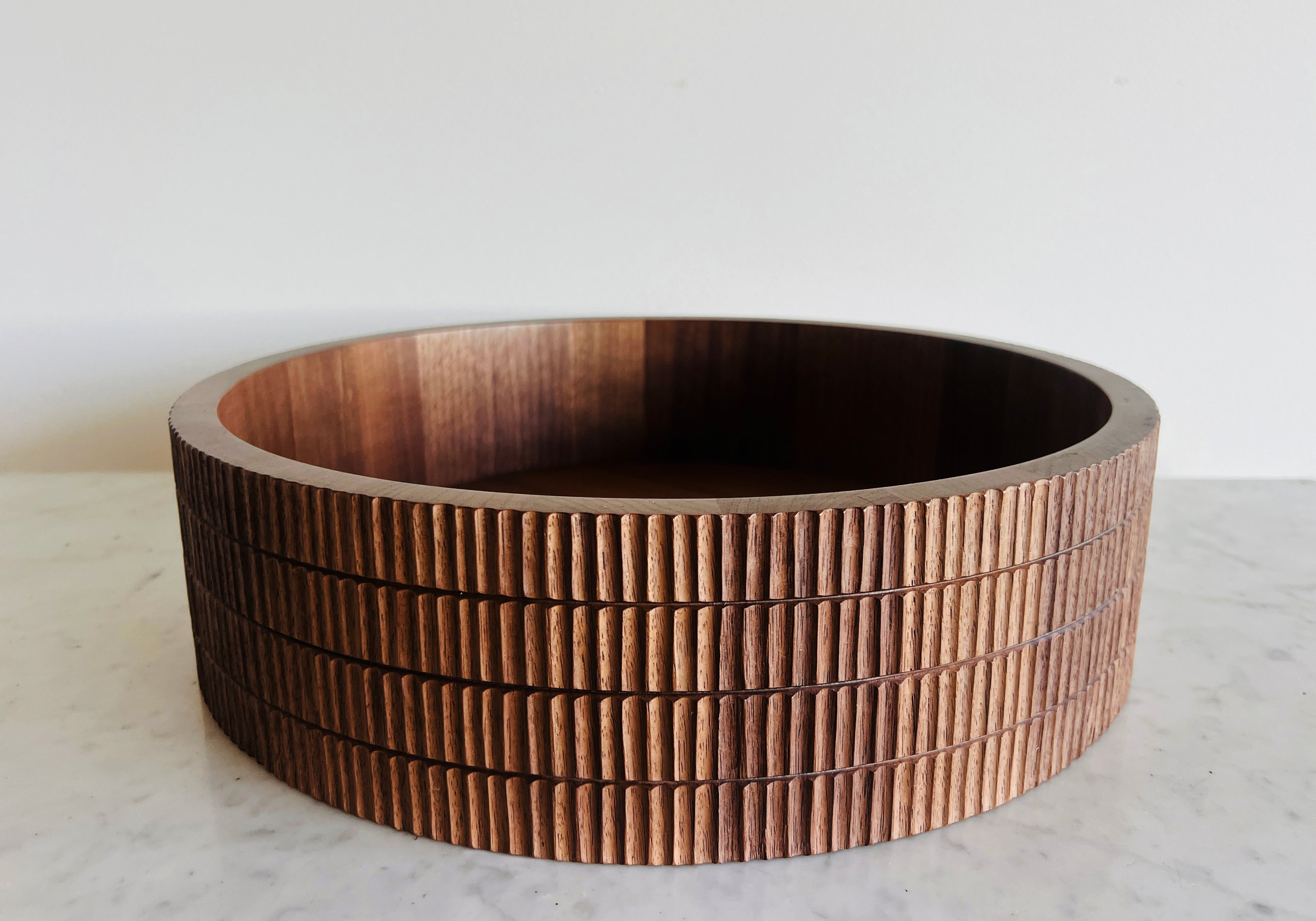 Wooden bowl with a ribbed texture on a light surface